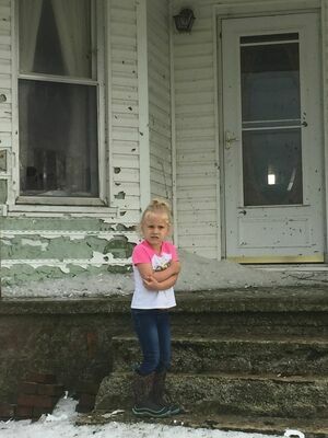 Logan Langston, daughter of Daniel and Christy Langston outside her great-grandparent’s home damaged from the May 3, 2020 storm. (Photo by Gina Langston)