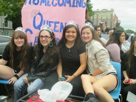 Homecoming queen candidates make themselves comfortable at the front of their float.