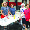 Rochelle Renkoski and Rebecca Coose serve hot dogs and water to Ruth Neill and Karrie Sands.