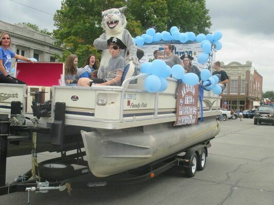 The freshman class rode through town on a boat with a sign that says “Take the Pirate’s Booty.”