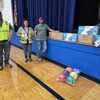 Mortenson Company employees (L-R) Duane White, Carol Severson, and Jake Goodell with items donated by the company to Greenfield schools last week. (Photo by Bob Jackson)